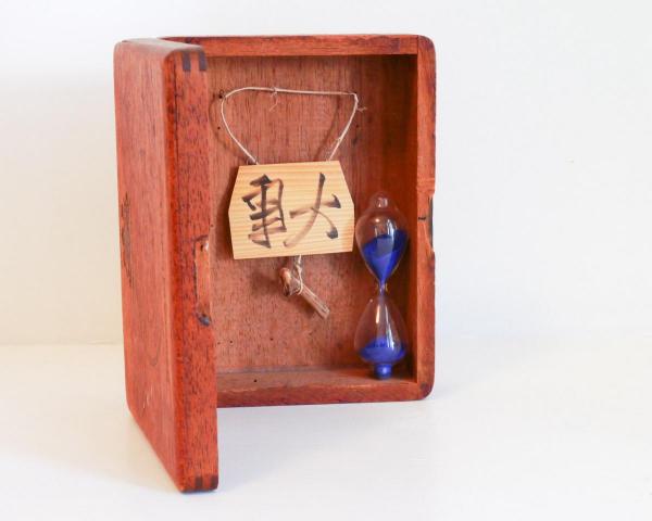 Calligraphy and hourglass in a vintage wooden cigar box
